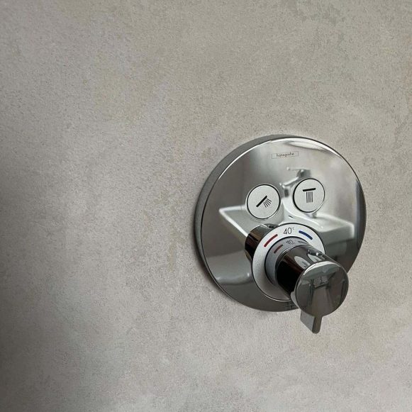 Shower handle furniture and earthy textured microcement wall detail